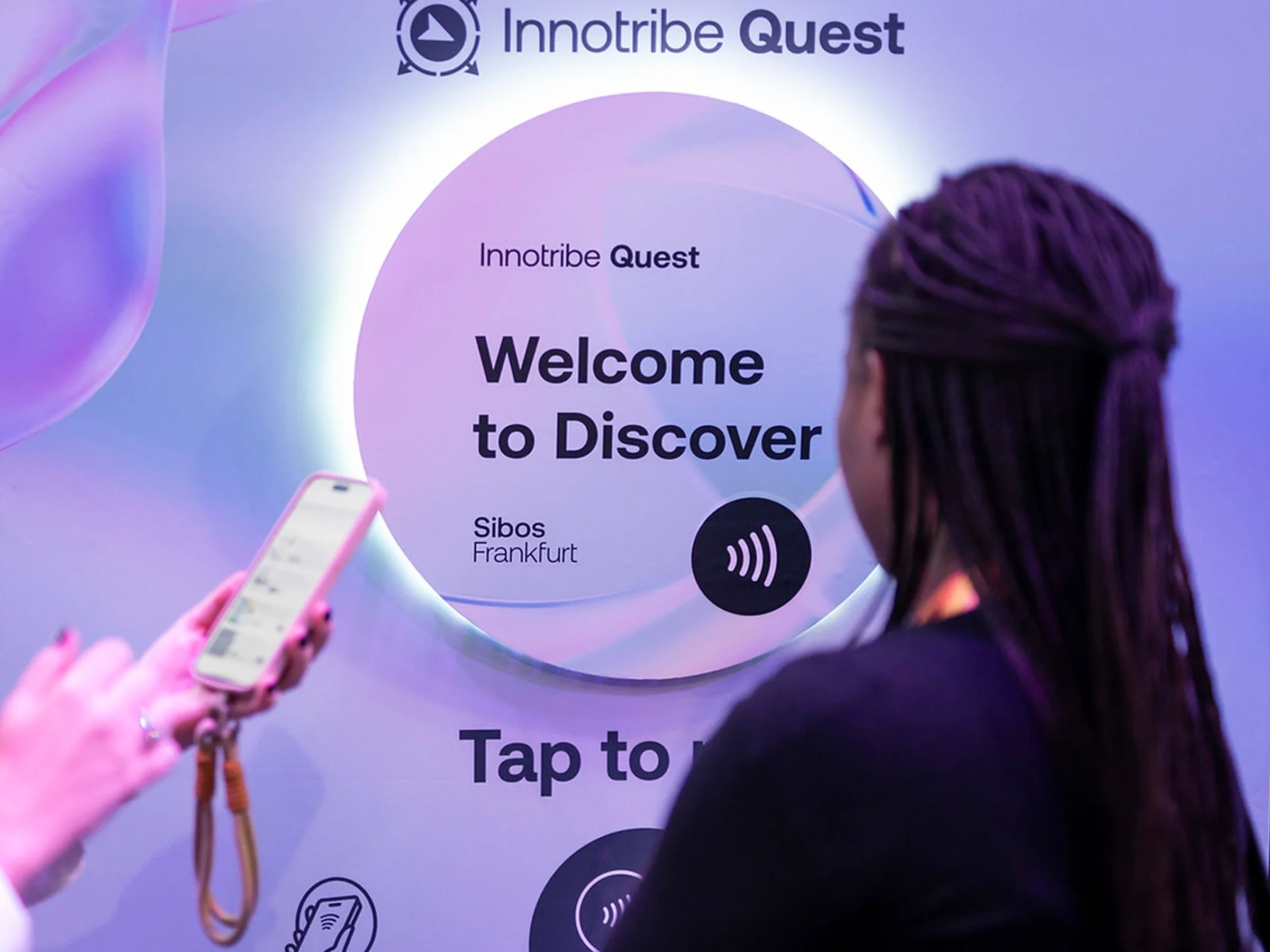 An attendee tapping a phone to the Innotribe Quest NFC totem at Sibos Frankfurt 2025